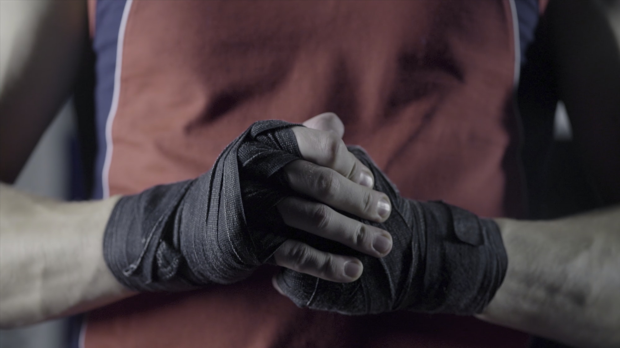 Man flexing his fists before a fight. Close-up of a young Thai boxer hands hemp ropes are wrapped